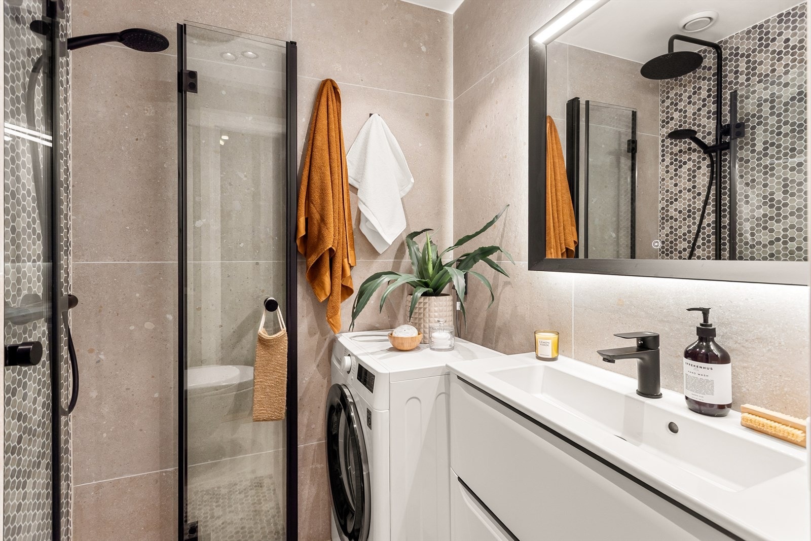 Lekkert innredet med vegghengt klosett, servant med innredning og dusjhjørne med svingbare glassdører. Galleribilde