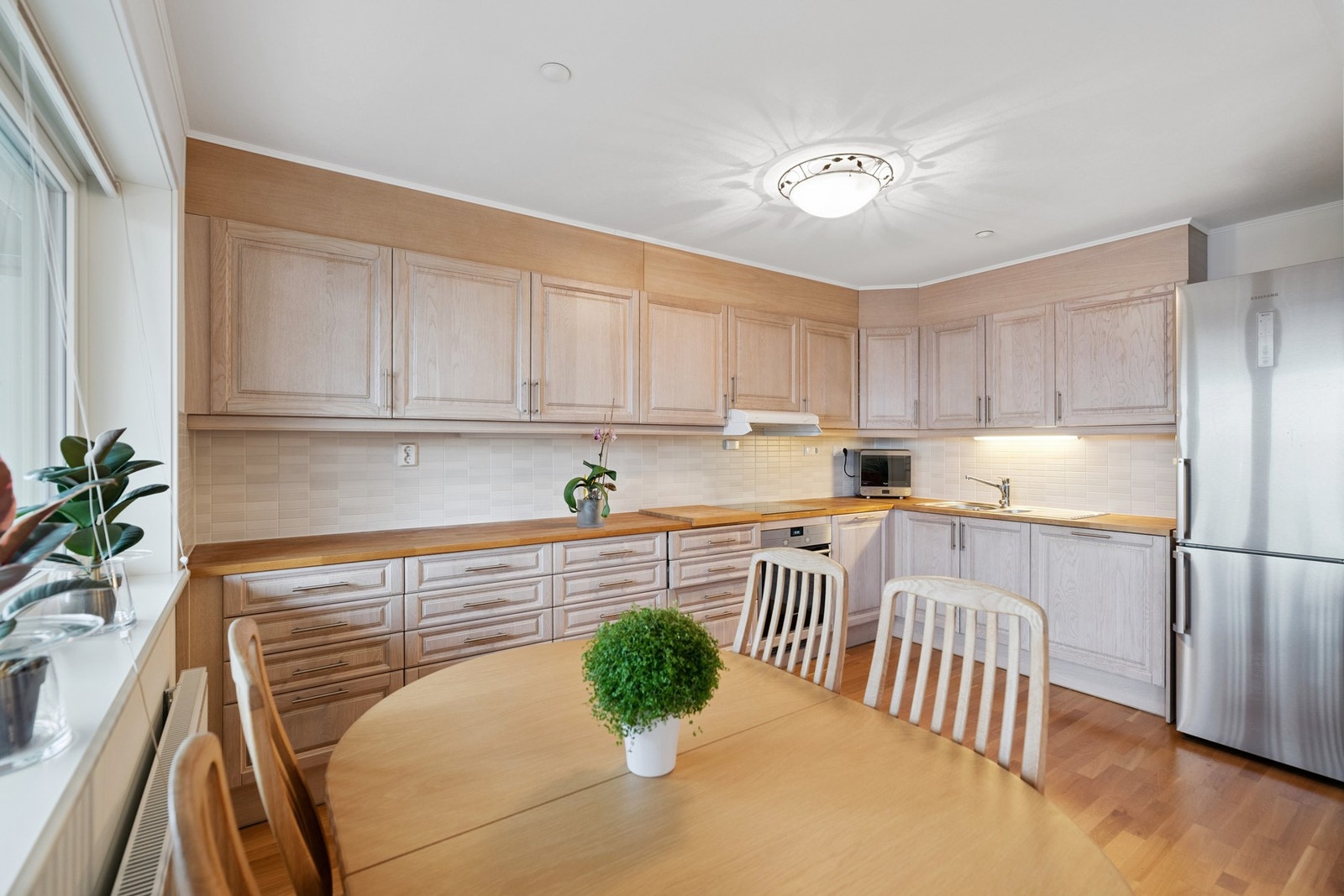 Kjøkkenet har en praktisk utforming med store benkeflater, gode lagringsmuligheter i både over- og underskap, samt integrerte hvitevarer som stekeovn, platetopp og oppvaskmaskin. Galleribilde