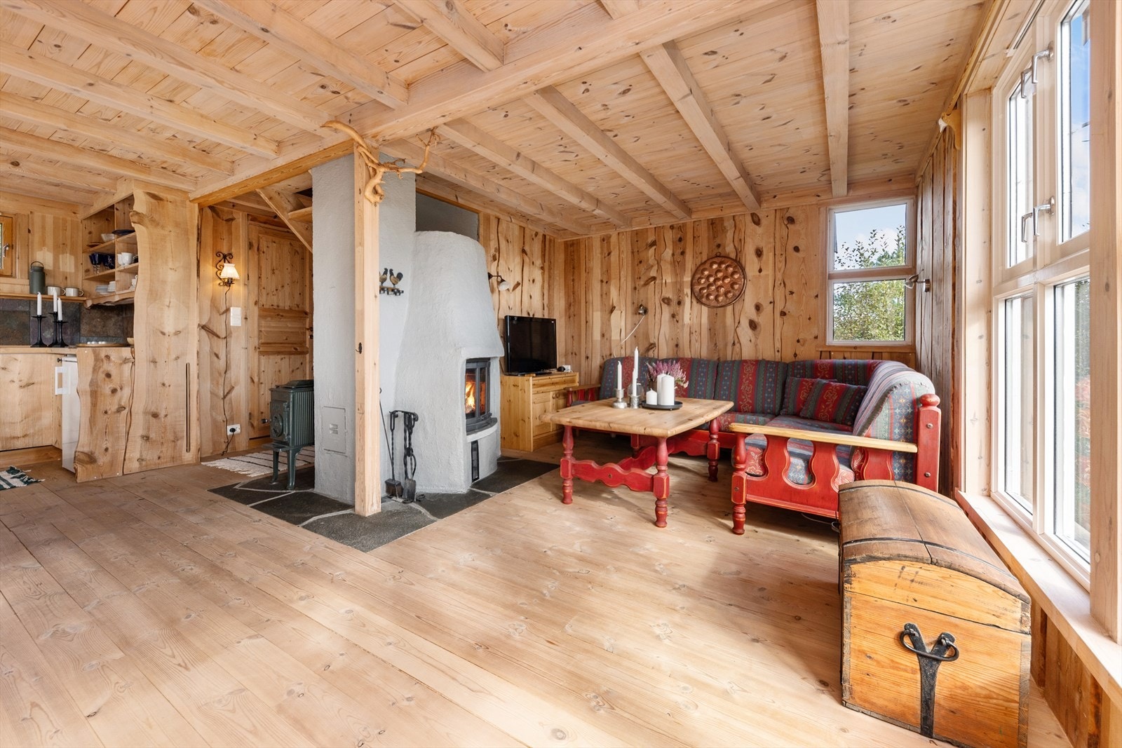 Koselig stue med peis og store vinduer som gir rikelig med naturlig lys. Perfekt for avslapning og hygge. Galleribilde