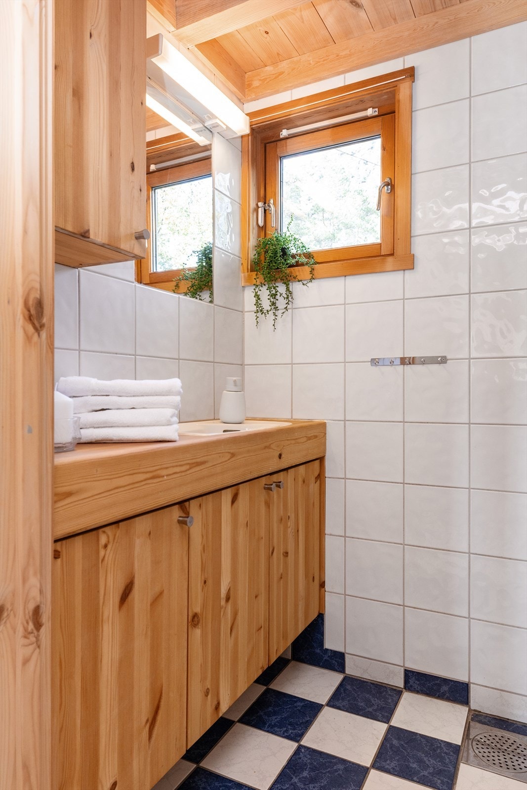 Flislagt bad med innredning av tre. Galleribilde