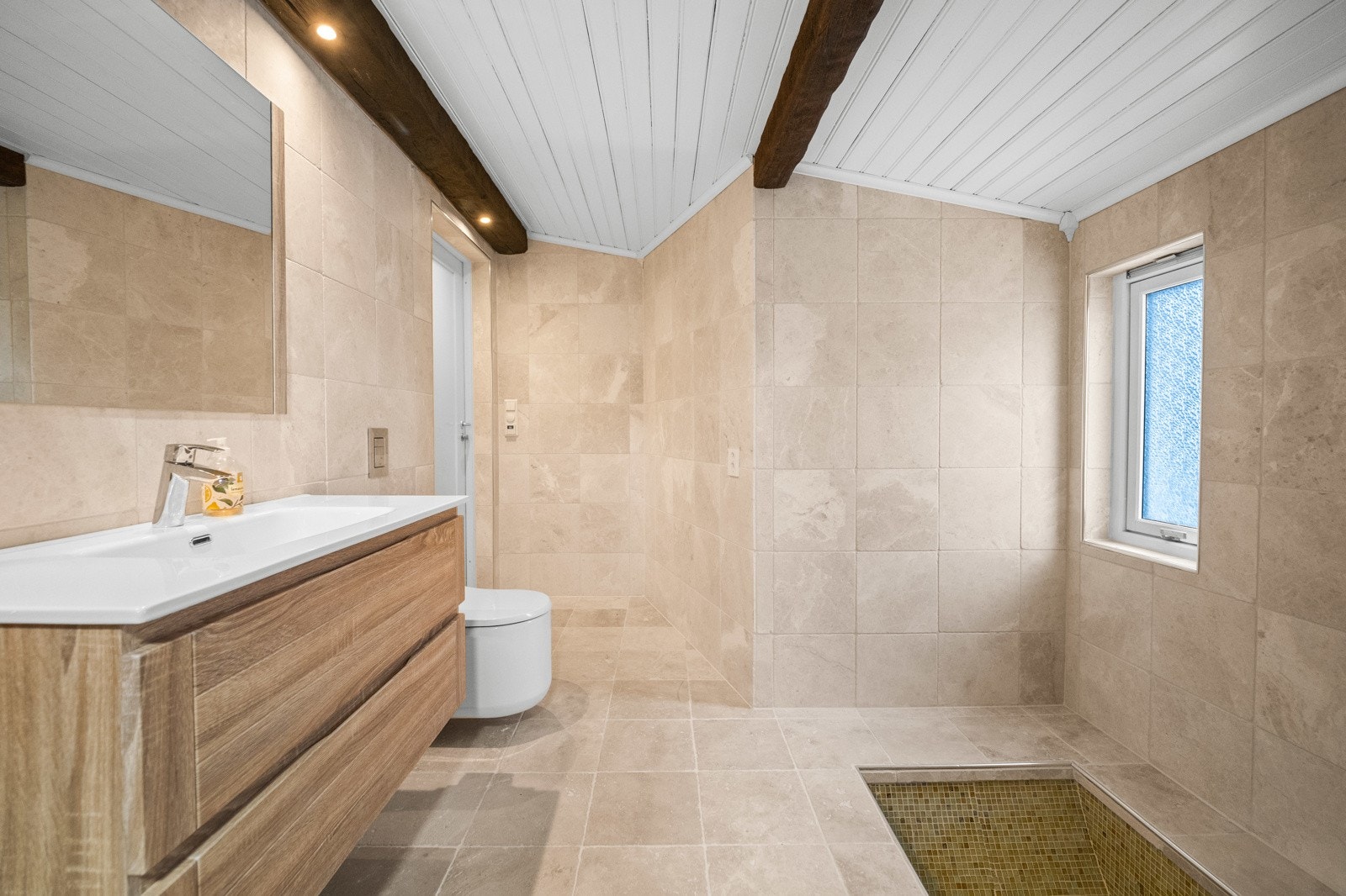 Badet er innredet med servant, baderomsinnredning og dusj, samt vegghengt toalett Galleribilde