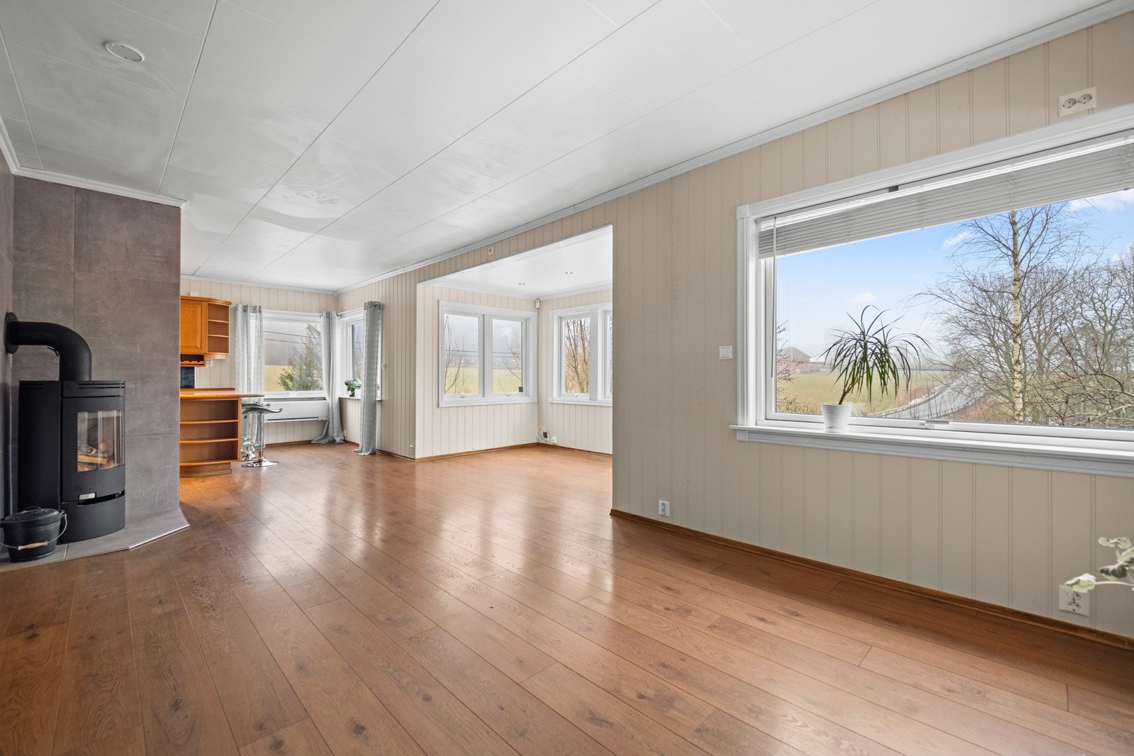 Lys og trivelig stue som får godt med innslipp av naturlig lys fra flere kanter Galleribilde