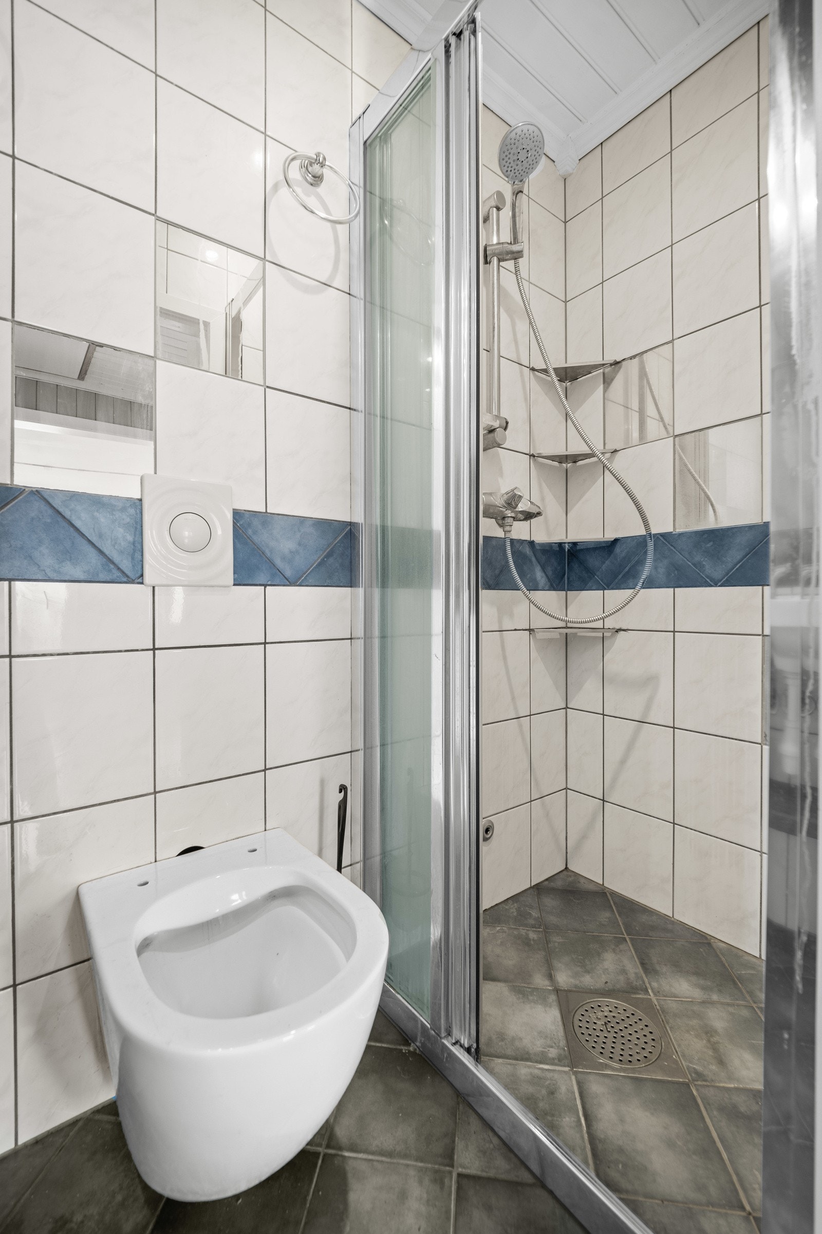 Badet er lite og består av dusj, toalett og servant Galleribilde