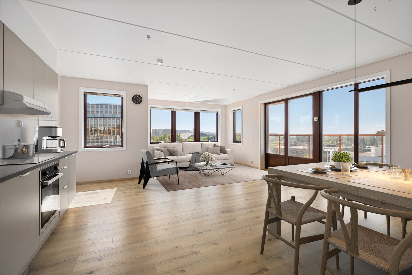 Lys og moderne stue med åpen kjøkkenløsning, store vindusflater og utgang til solrik balkong med flott utsikt. Galleribilde