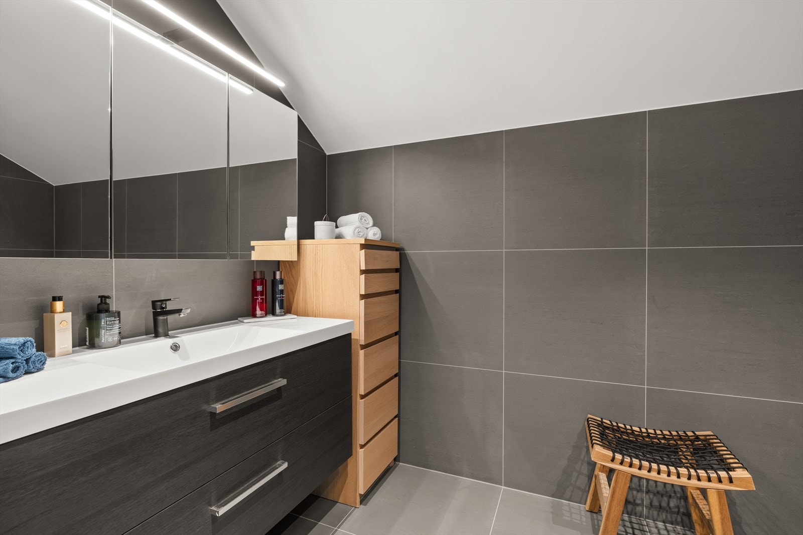 Hovedbad ligger i 2. etasje, praktisk plassert i nærheten av de fire soverommene. Rommet fremstår moderne og delikat, med flislagte gulv og vegger i tidløst design. Galleribilde