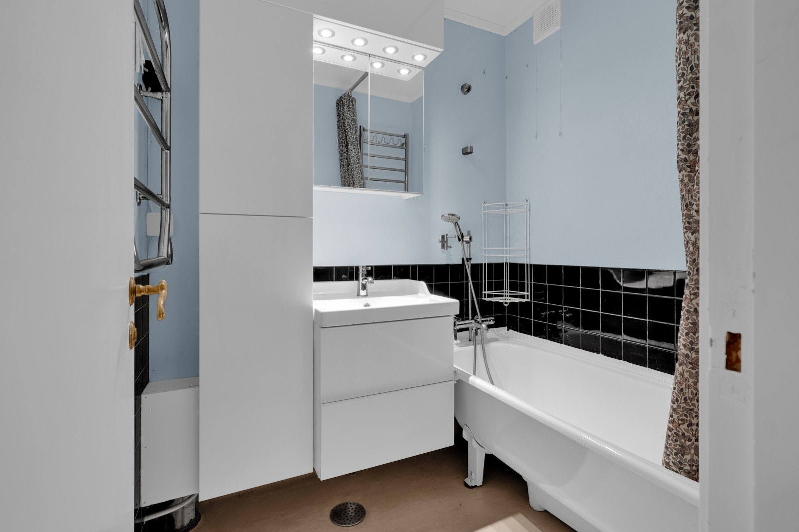 Baderommet har gulv med belegg, vegger med kombinasjon av fliser og malte overflater, samt malt tak. Galleribilde