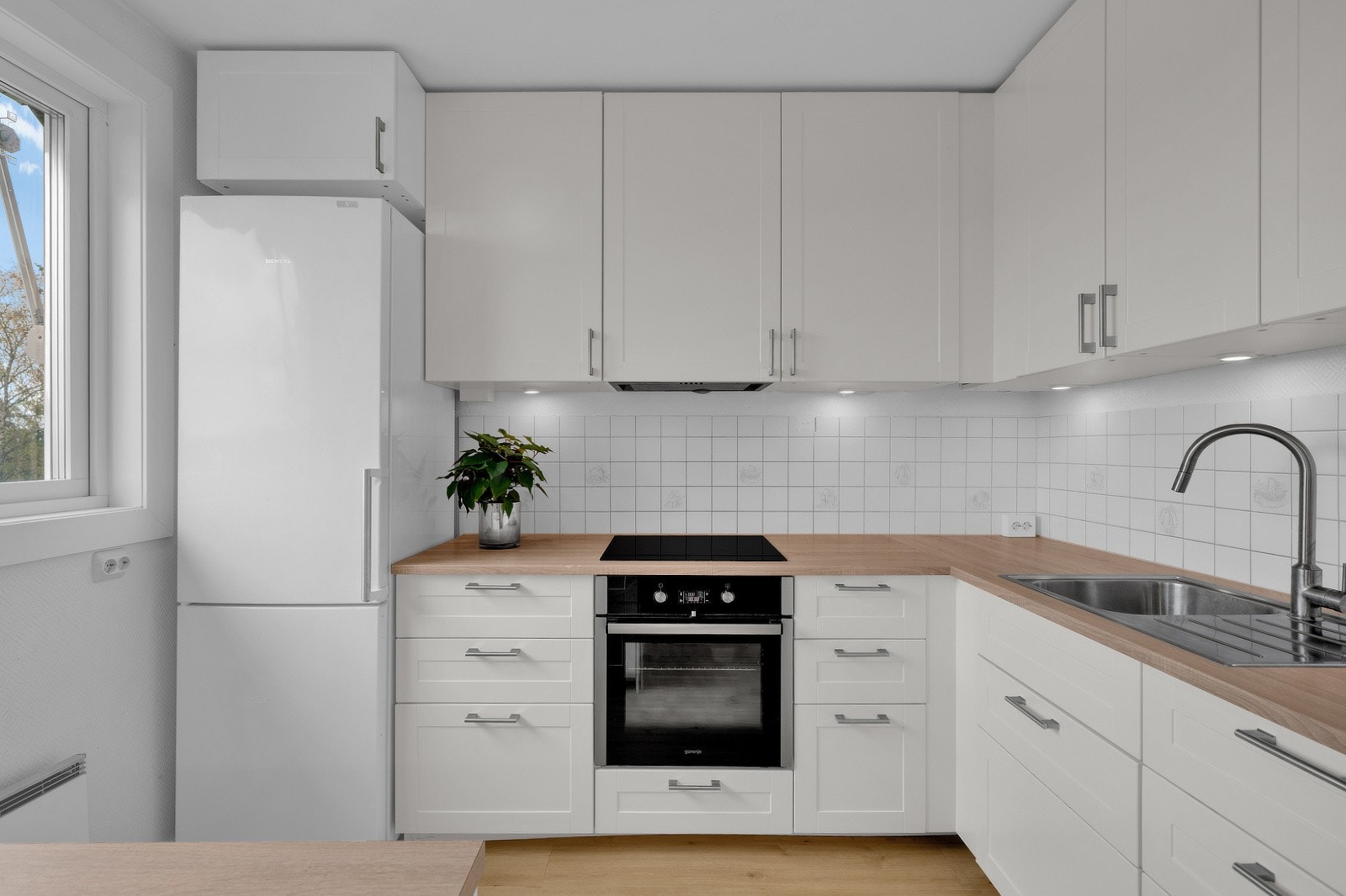 Her er det rikelig med både skap- og benkeplass. Over benk er det flislagte veggflater som gir et stilrent og praktisk uttrykk. Galleribilde