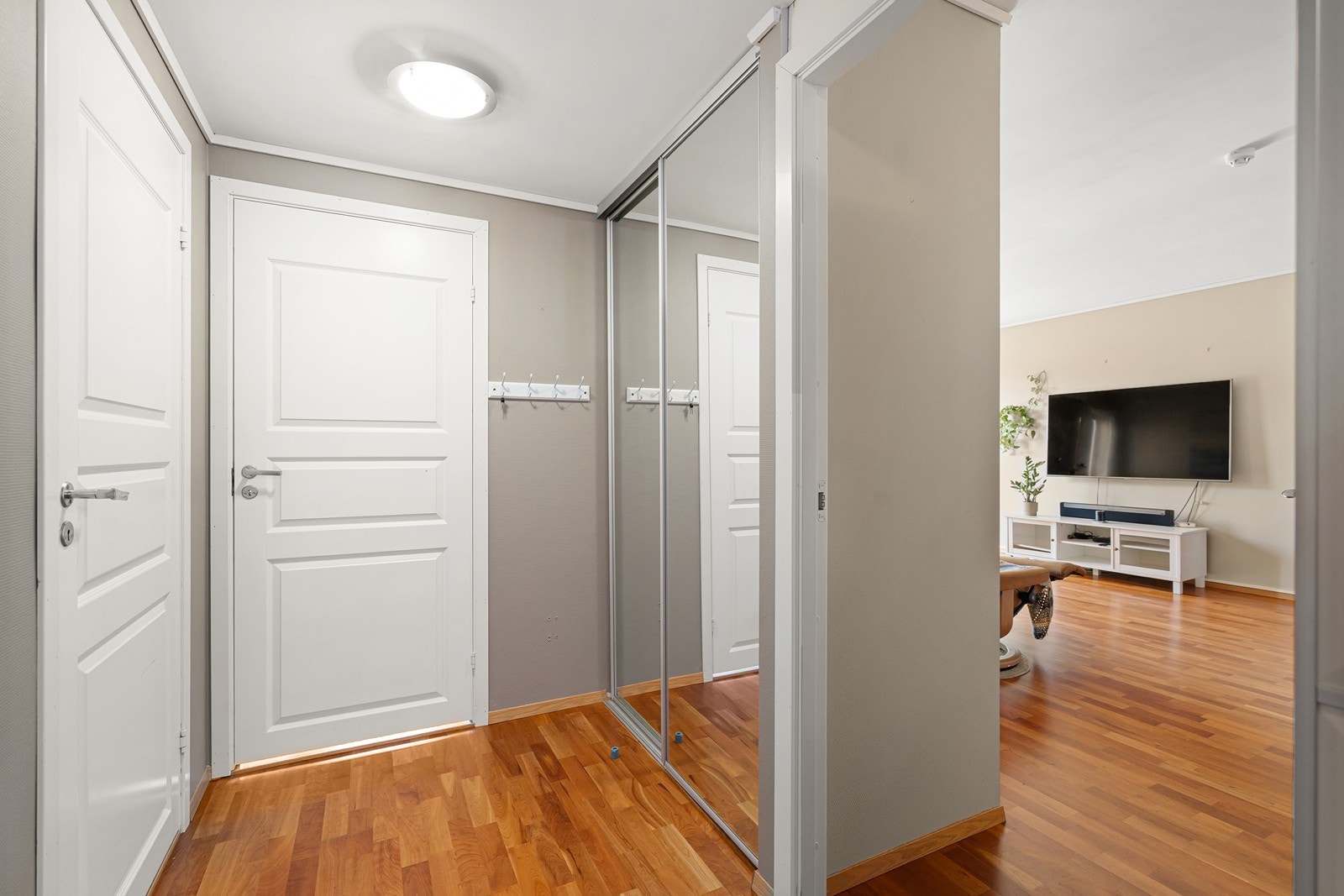 Innbydende inngangsparti som setter tonen for leiligheten. God plass til oppbevaring av yttertøy og sko i speilgarderoben. Galleribilde