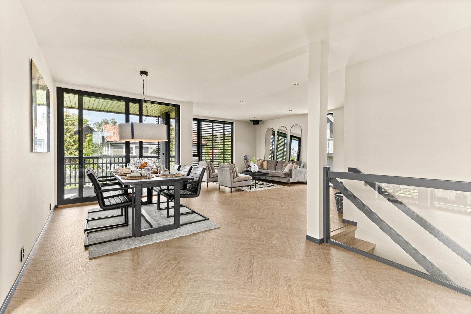 Lys stue med store vindusflater og skyvedør ut til solrik, vestvendt balkong. Galleribilde