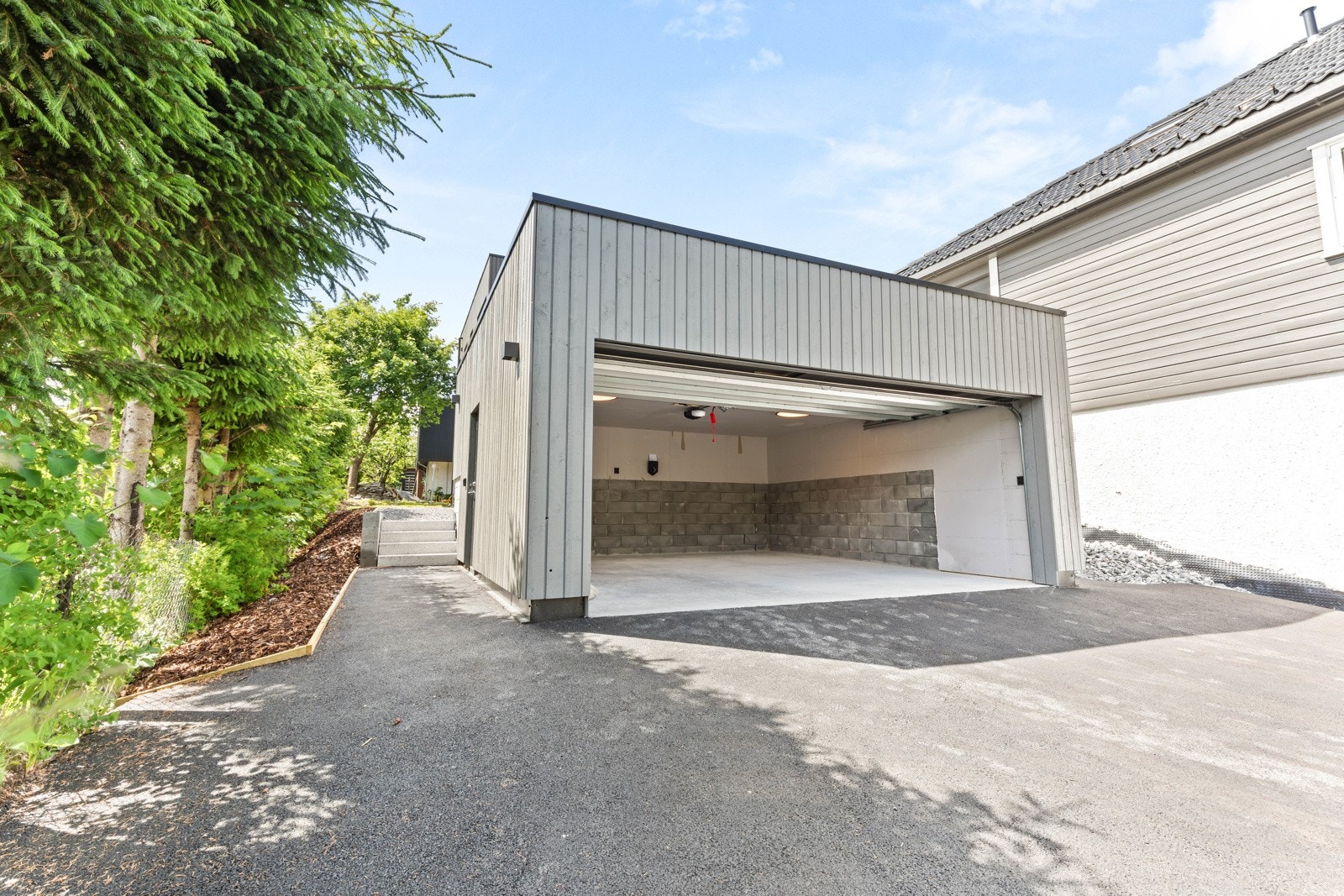 Frittliggende dobbelgarasje med hurtiglader. Galleribilde
