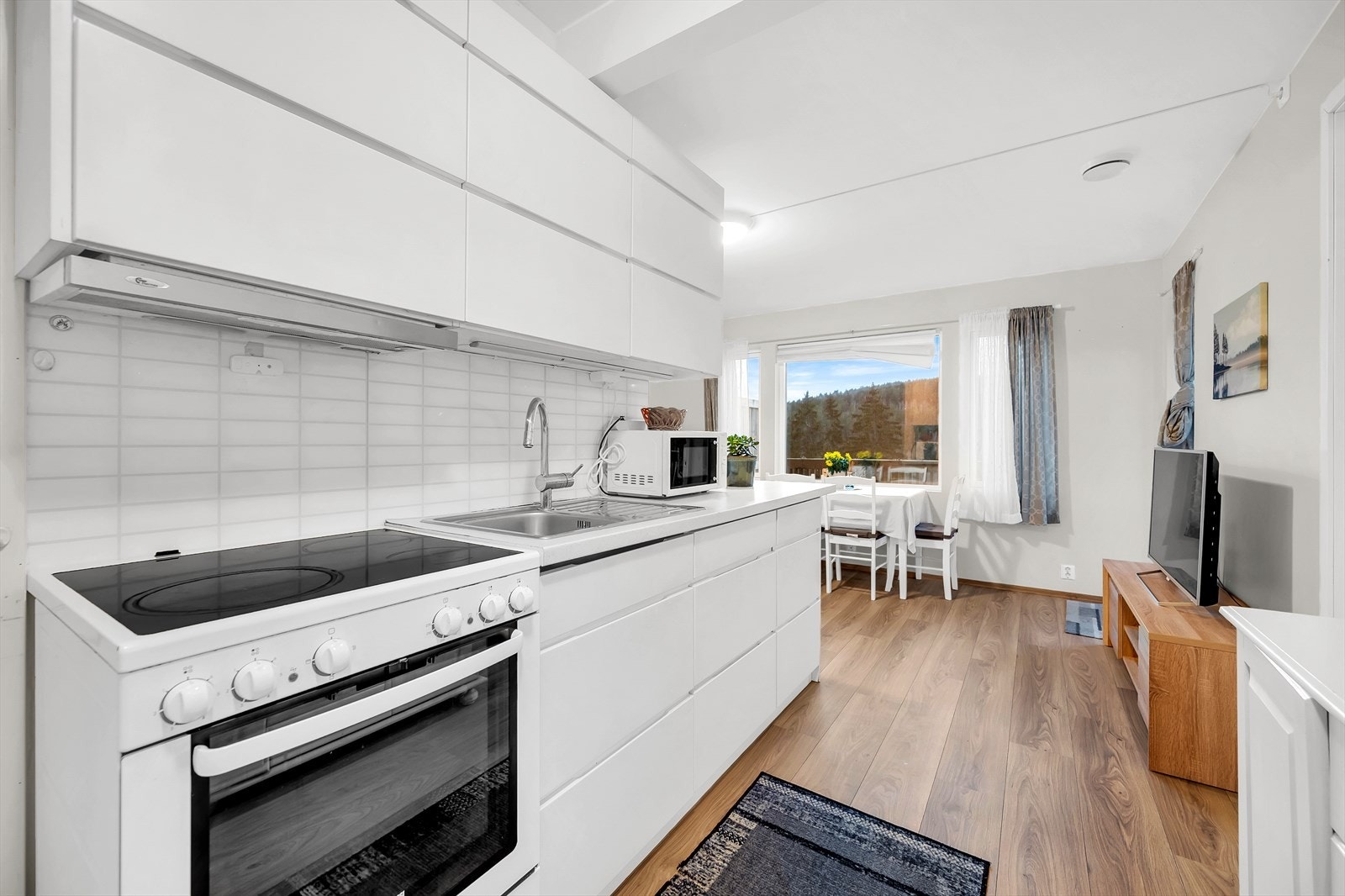 Her har man et praktisk kjøkken med frittstående komfyr på enden av innredningen. Kjøleskap/fryser plassert i boden. Galleribilde