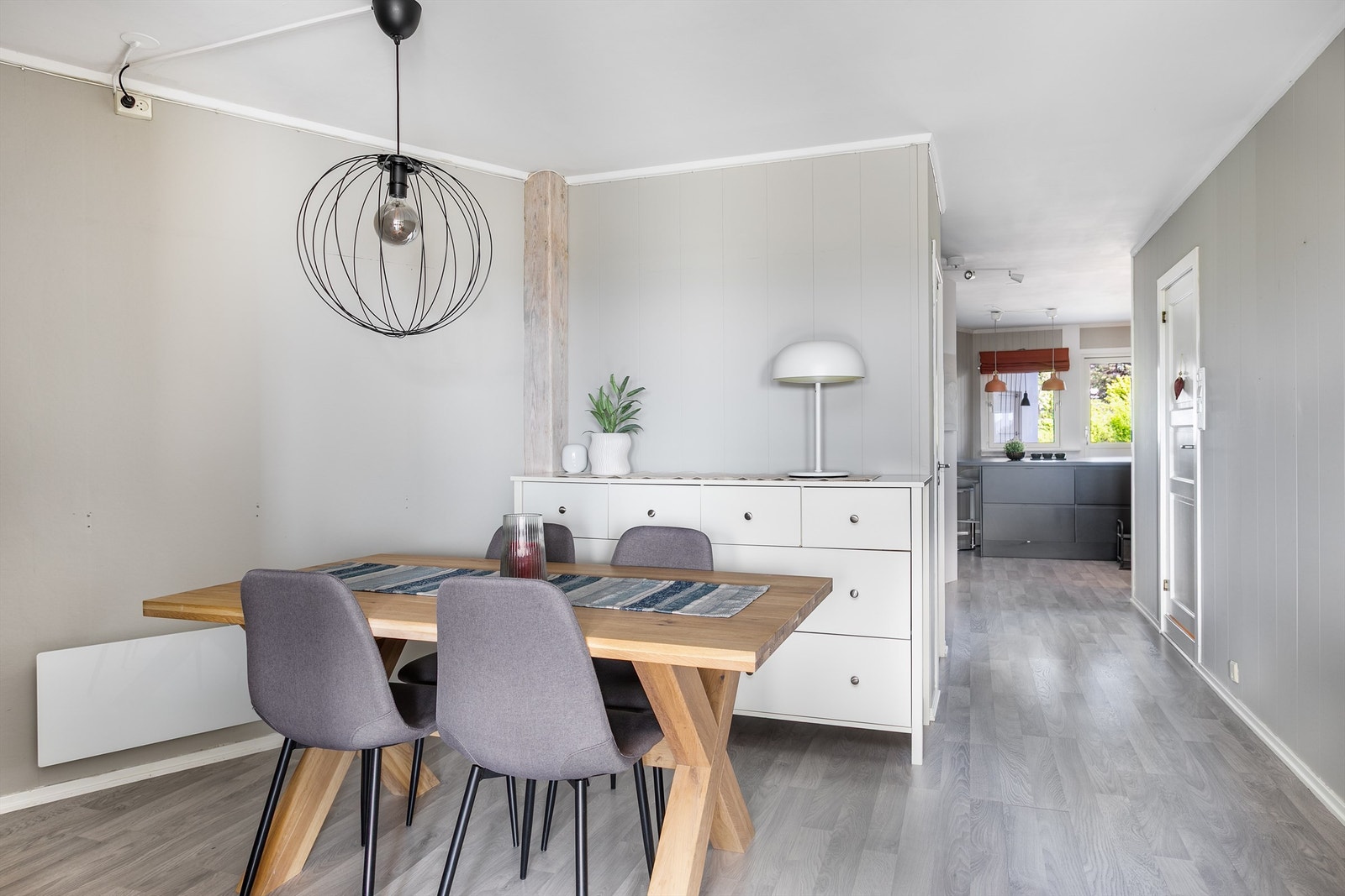 Laminat lagt gjennomgående mellom stuen og kjøkkenet skaper helhet. Galleribilde