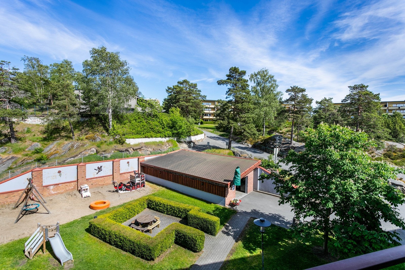 Mens du sitter ute på kjøkkenbalkongen kan du også holde oppsyn med egne barn på lekeplassen rett nedenfor. Galleribilde