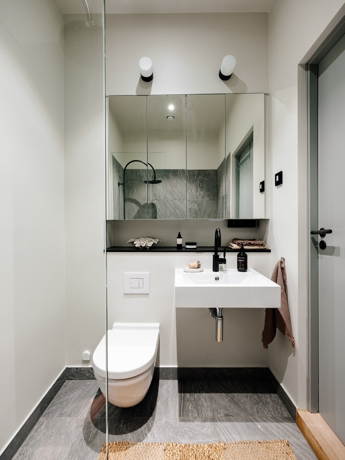 Dusjsone med både regn- og hånddusj, veggmontert wc, servant med armatur og speilskap over. Galleribilde