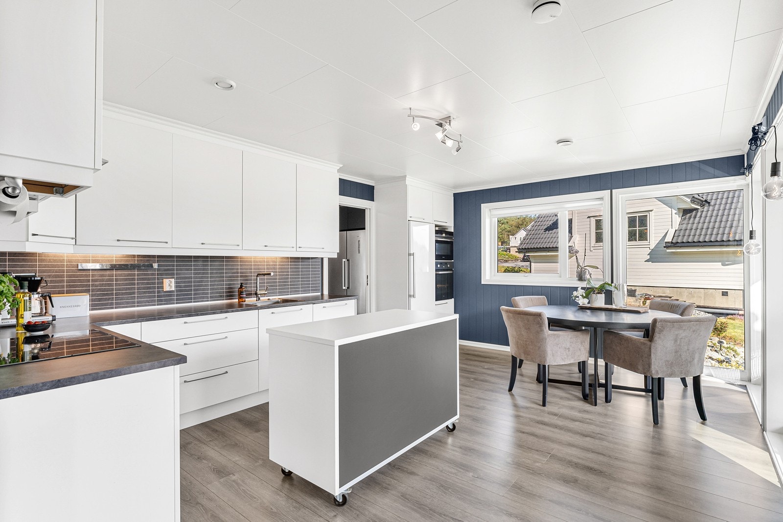 Stilren kjøkkeninnredning med slette fronter og benkeplate i laminat med stålvask. Galleribilde