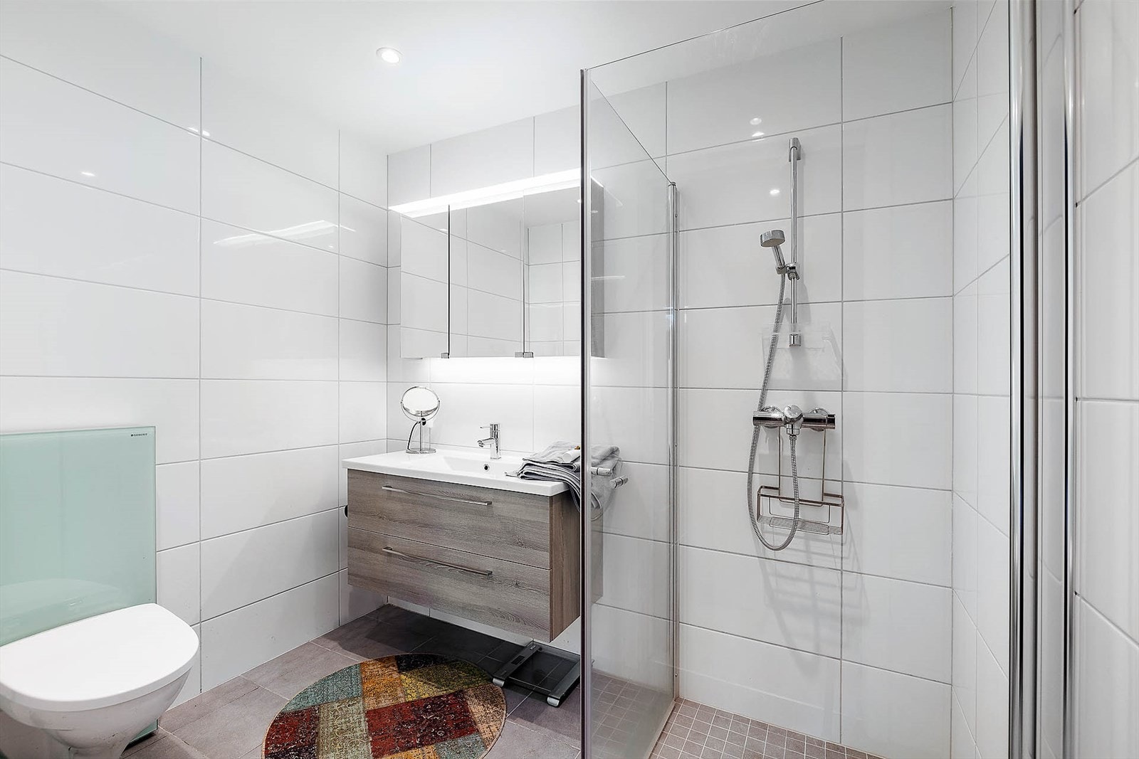 Badet er innredet med dusj, servant i innredning og toalett Galleribilde