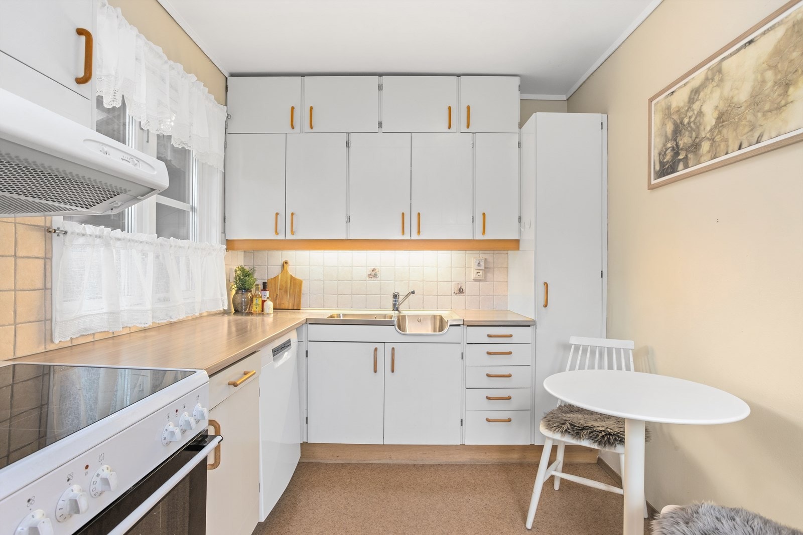 Laminert benkeplate med nedfelt dobbel oppvaskkum. Plass til et lite, hyggelig spisebord på kjøkkenet. Galleribilde