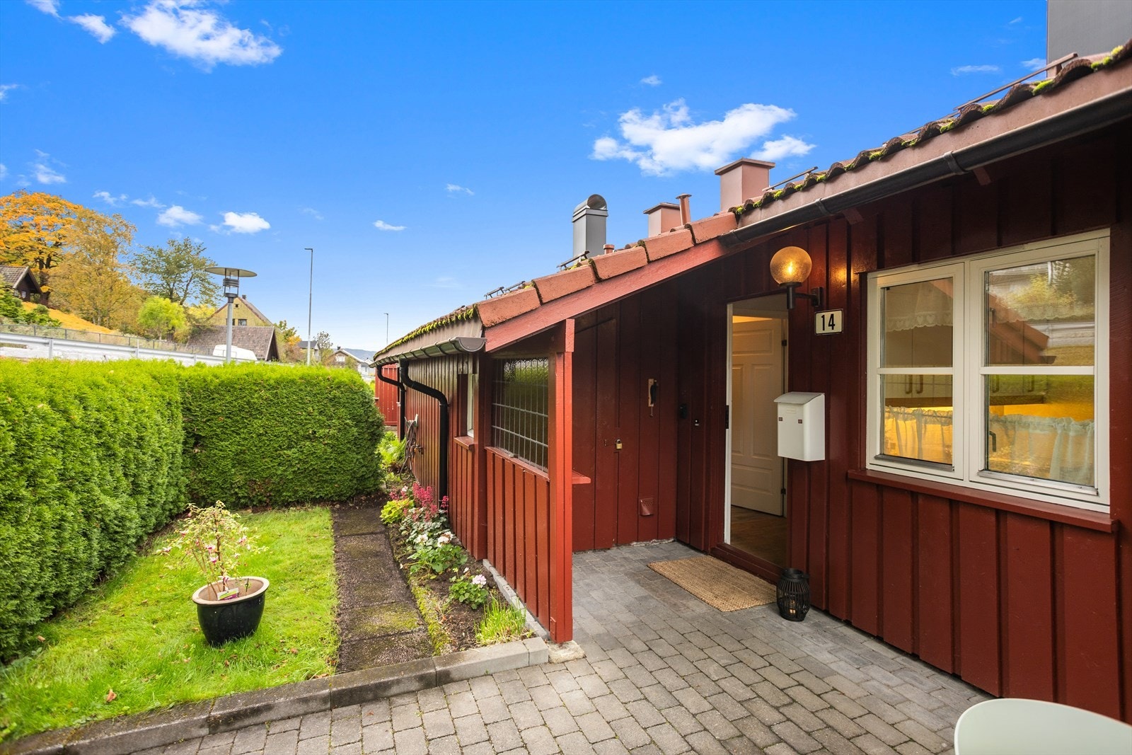 Koselig inngangsparti med belegningsstein og en liten hageflekk. Galleribilde