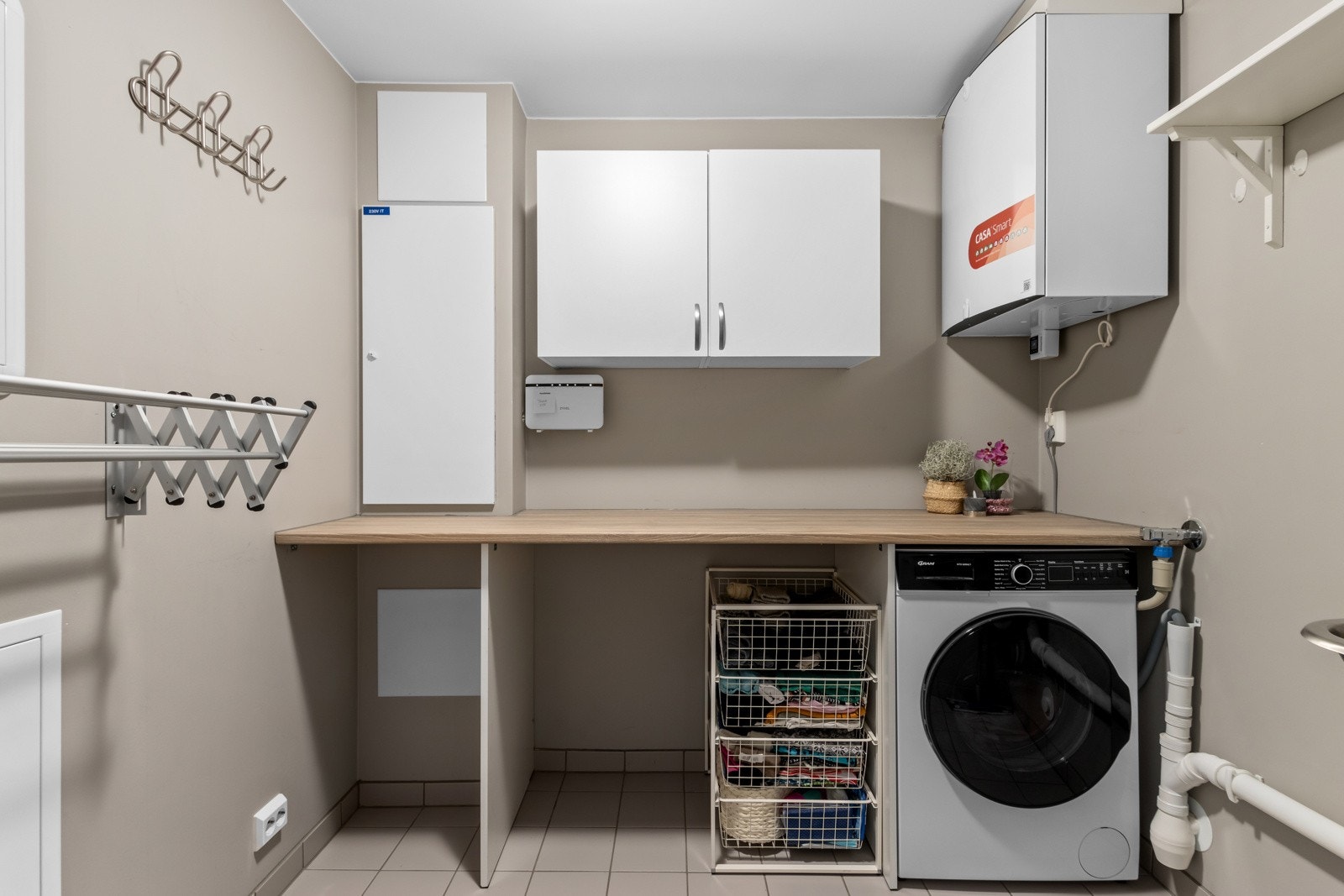 Separat og praktisk vaskerom med skap og benk, samt stativ for klestørk. Galleribilde