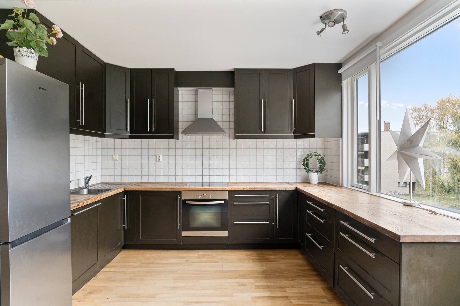 Praktisk kjøkken fra 2007 med Kjøkkeninnredning med profilerte fronter og benkeplate av heltre. Videre er kjøkkenet flislagt mellom overskap og underskap. Kjøkkenet er utstyrt med integrerte hvitevarer som stekeovn, platetopp og oppvaskmaskin. Frittståend Galleribilde