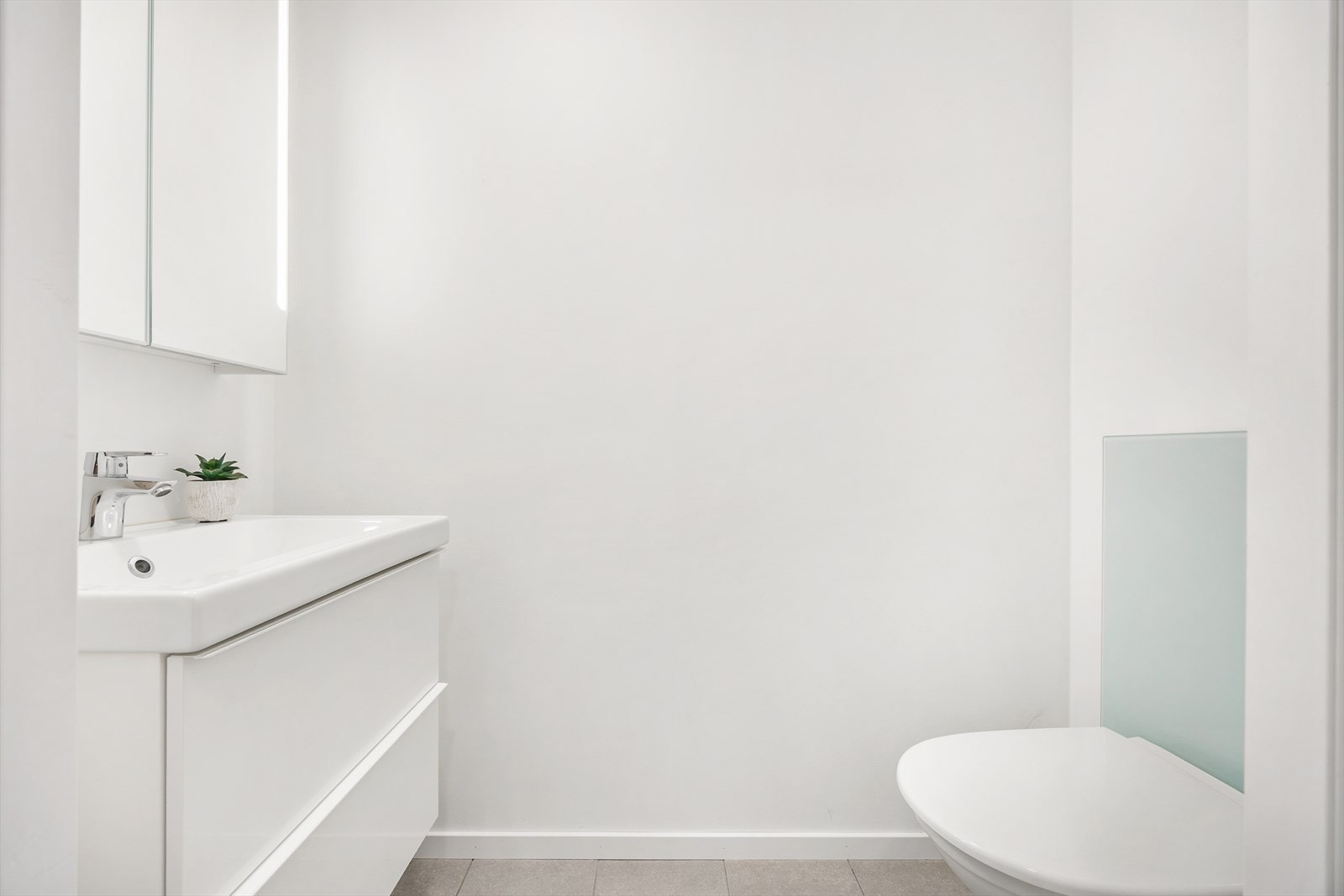 Praktisk toalettrom i første etasje, utstyrt med gulvvarme og vegghengt toalett. Galleribilde