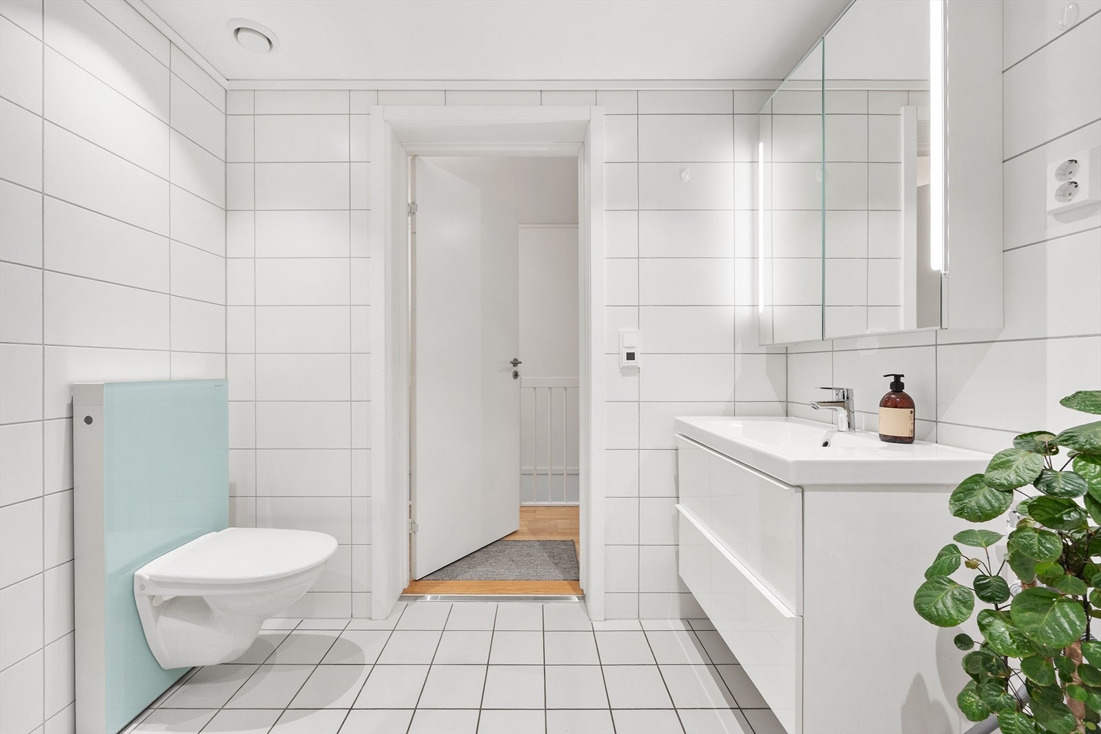 Delikat, helfliset bad med vegghengt toalett og servantinnredning med god oppbevaring. Galleribilde