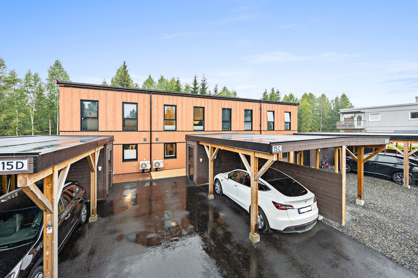 Oversiktlig og ryddig adkomst med asfaltert gårdsplass og faste parkeringsløsninger. Galleribilde