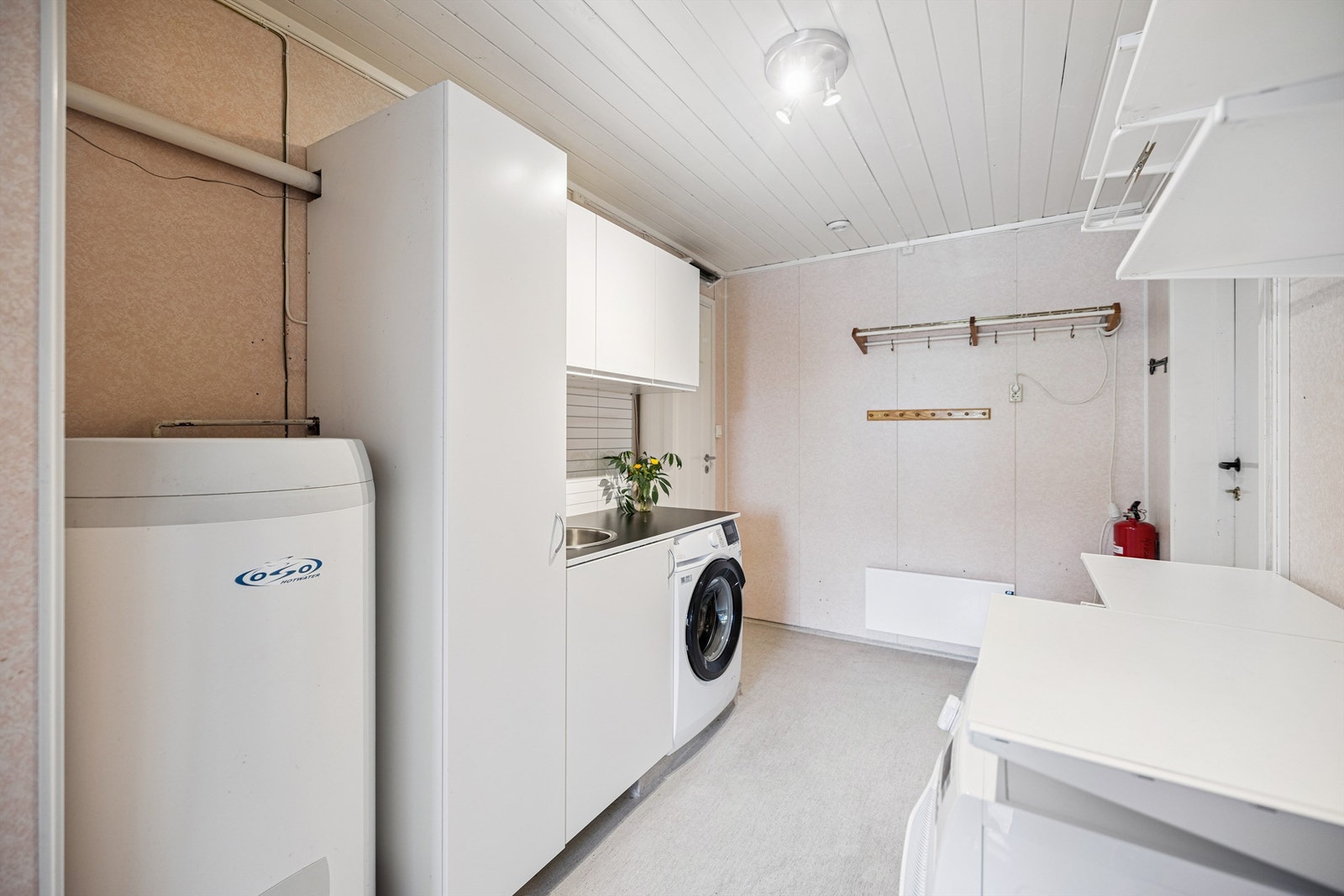 Praktisk vaskerom med opplegg for vaskemaskin og en varmtvannsbereder fra 2017. Galleribilde