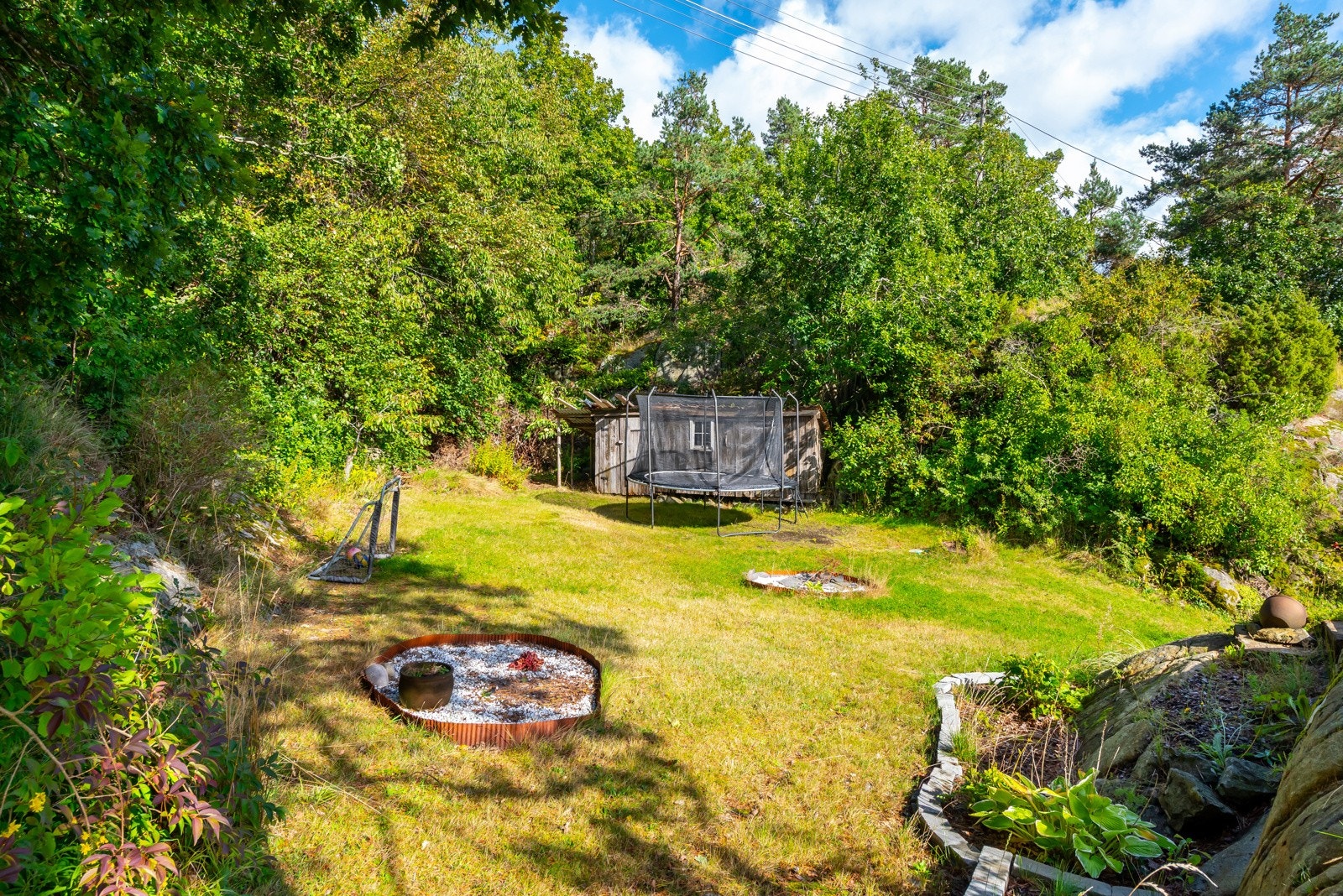 Eiendommen opparbeidet med plenarealt og fine bed mot fjell og naturtomt. Galleribilde