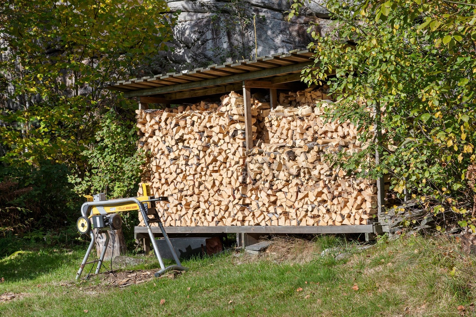 Overbygget vedlager bak i hagen (står utenfor tomtegrensen) Galleribilde