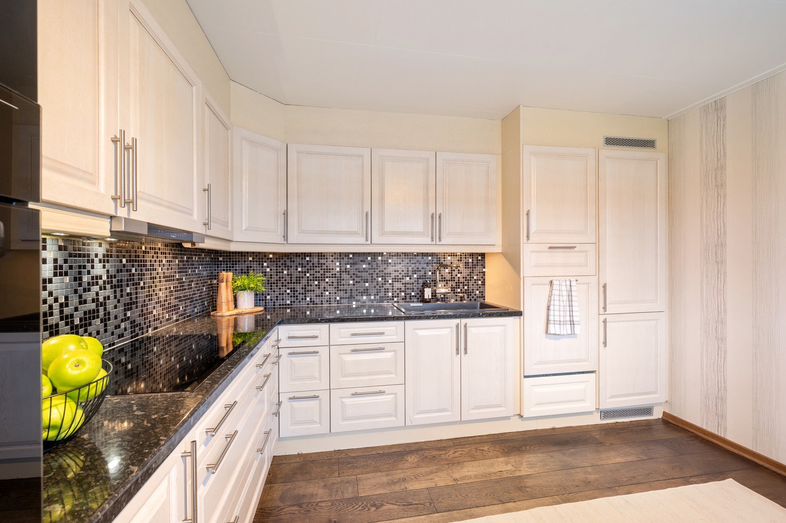 Kjøkkenet er innredet med integrerte hvitevarer som platetopp, stekeovn, mikrobølgeovn, kjøle/fryseskap og oppvaskmaskin som medfølger i handelen. Galleribilde