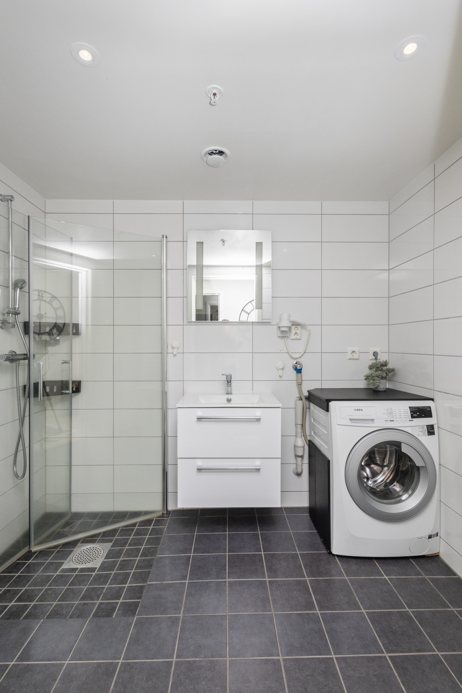 Tidløst, flislagt baderom med varmekabler. Galleribilde