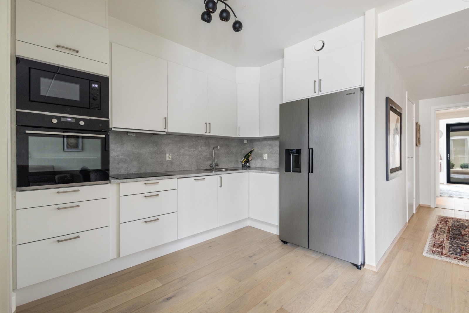 Pen kjøkkeninnredning med slette fronter, integrert stekeovn og mikro i ergonomisk høyde. Galleribilde