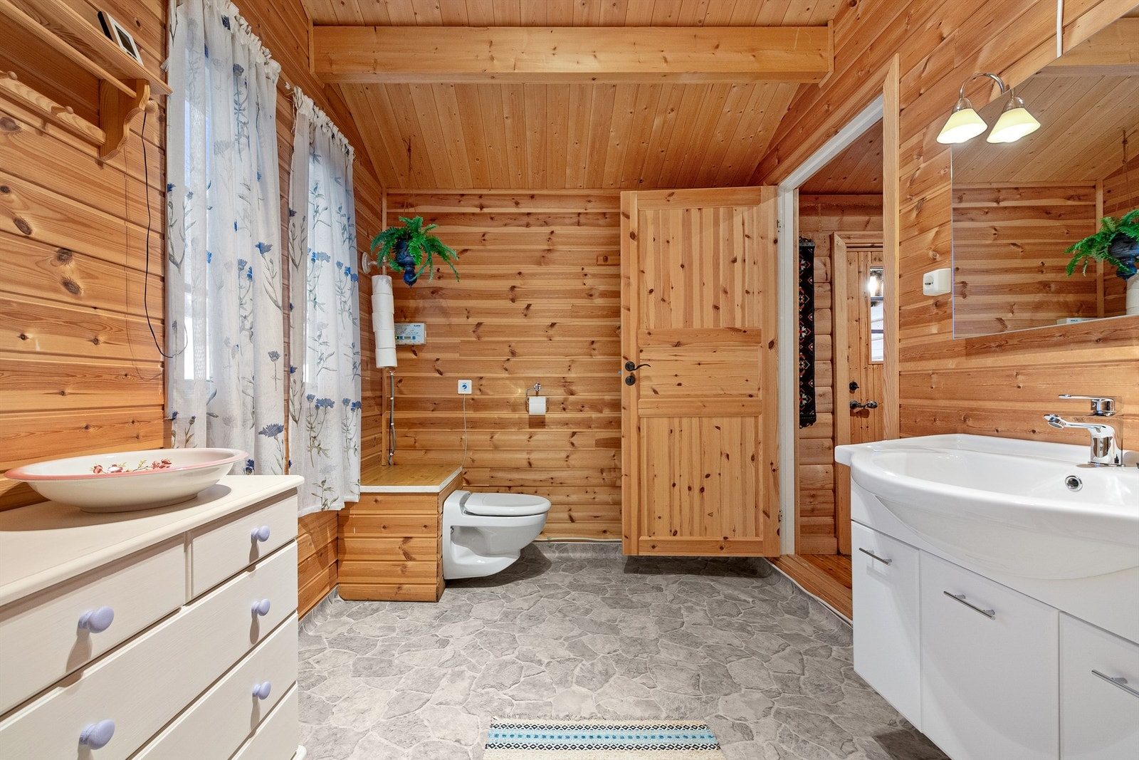 Bad fra ca. 2004 med gulvbelegg med gulvvarme på gulv, panelte vegger og tak Galleribilde