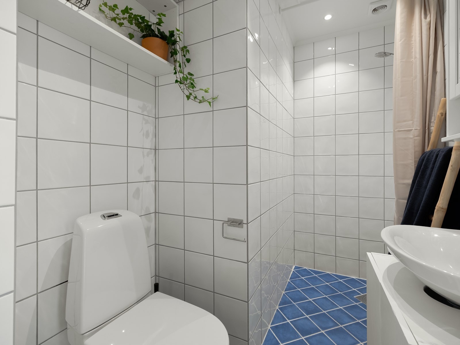 Flislagt baderom med behagelig gulvvarme og downlights. Galleribilde