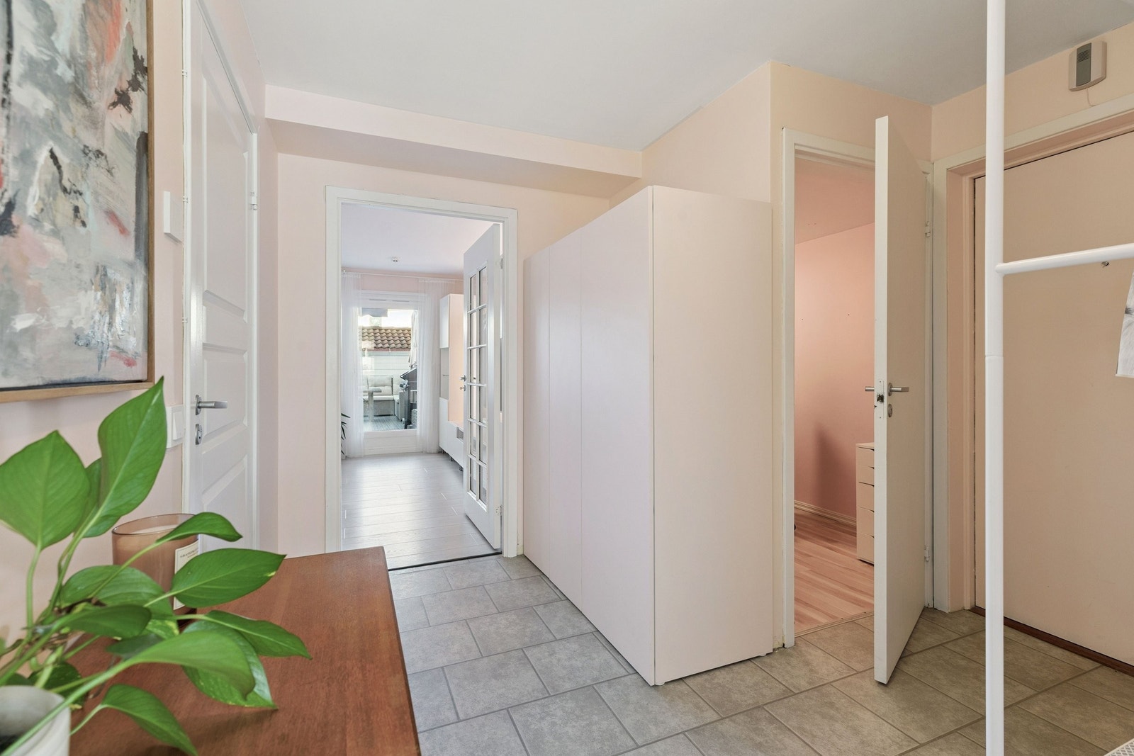 Praktisk entré med god plass til jakker, sko og oppbevaring i skap. Fra inngangspartiet har du tilgang til alle rom i leiligheten, noe som gir en naturlig og funksjonell romflyt. Galleribilde