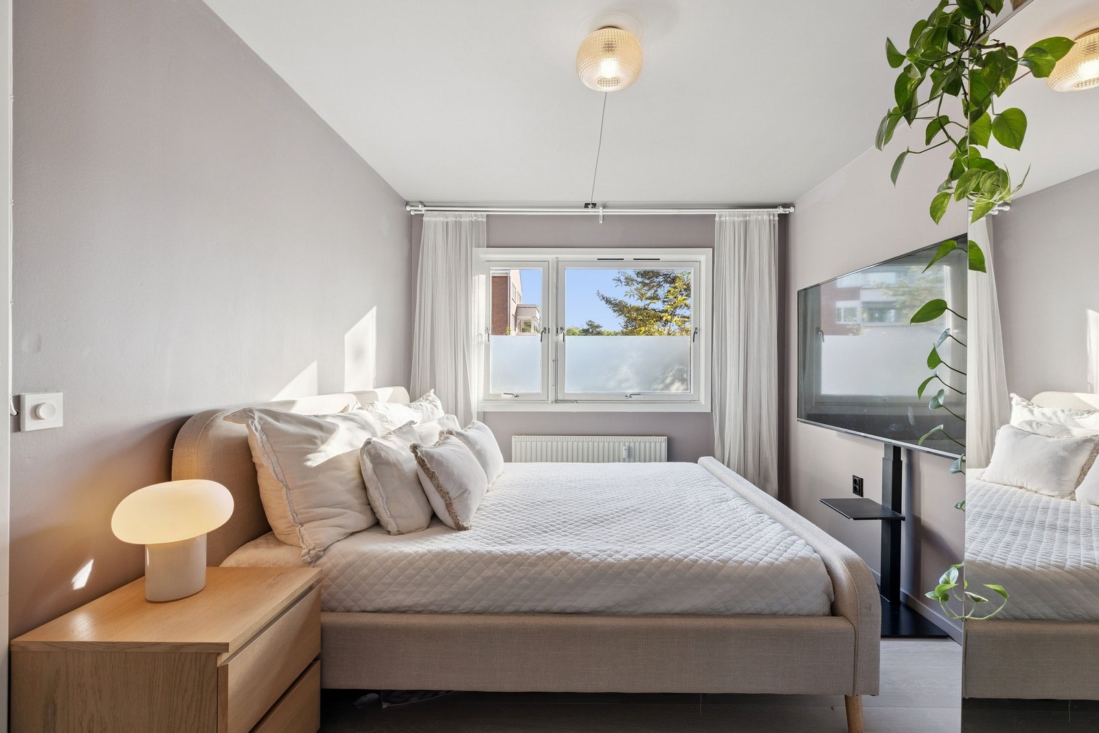 Romslig soverom med plass til dobbeltseng og garderobeskap. Det er også plass til en liten arbeidsstasjon, noe som gjør rommet fleksibelt og praktisk for deg som trenger et rolig hjørne til hjemmekontor. Litt mørkere interiør gir en lun atmosfære. Galleribilde