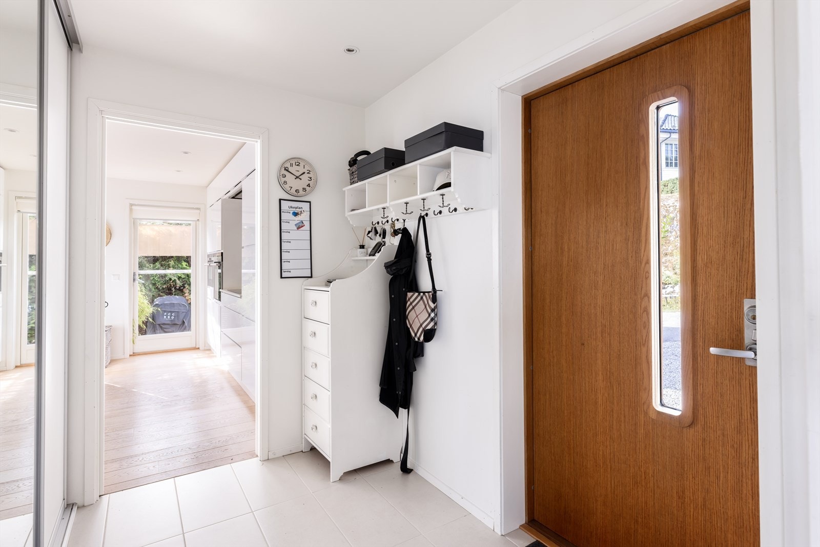 Huset har to inngangsdører ved siden av hverandre. Entréen kan videre deles mellom de to dørene ved en skyvedør. Løsningen er laget for å kunne ha mulighet for en entré til gjester, og en til hverdagsbruk. Legg merke til de påkostede dørene i massiv eik. Galleribilde