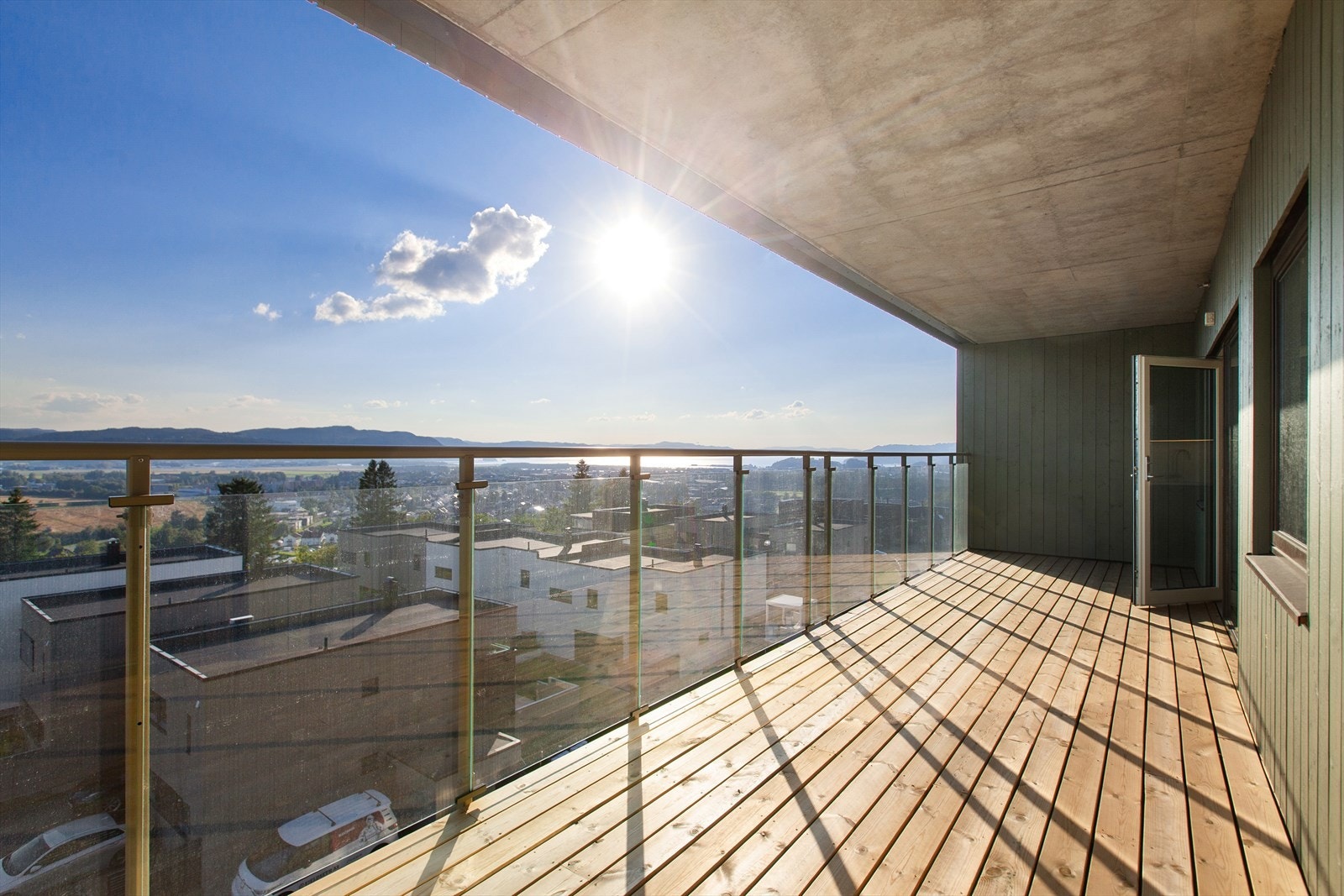 Takoverbygget veranda på hele 21 kvm. Gode solforhold fra ca. 10-22 sommerstid. Her har man optimale solforhold og fantastisk utsikt fra vinduer og den romslige verandaen mot fjorden og byen. Galleribilde