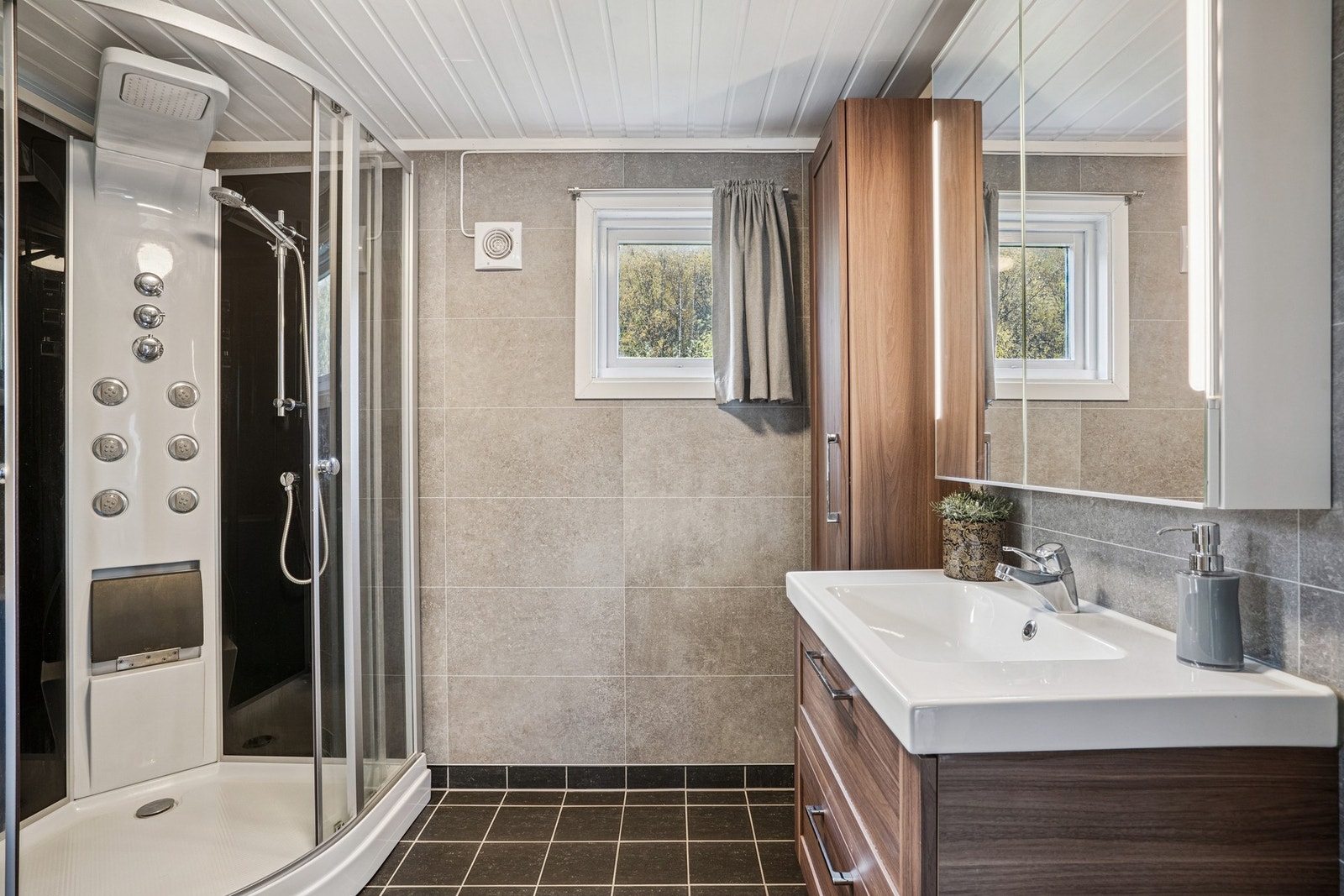 Romslig dusjkabinett og elektrisk vifte gir komfort og god ventilasjon på badet. Galleribilde