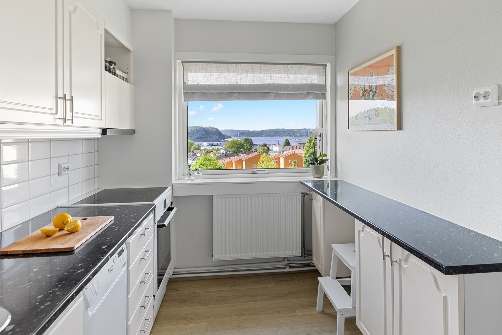 Den laminerte benkeplaten gir god arbeidsflate, og hvite fliser mellom benkeplate og overskap gir både et rent utseende og enkel rengjøring. Galleribilde