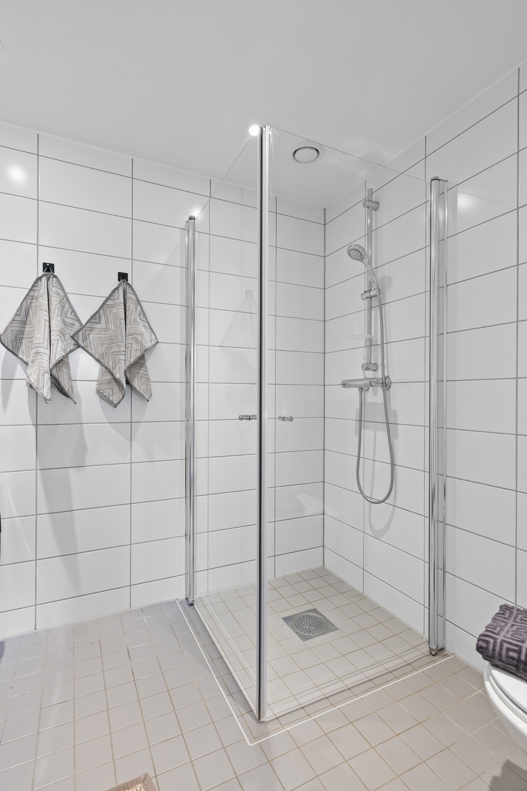 Rommet er helfliset med varme i gulvet, flislagte vegger og nedfelt himling med downlights for et gjennomført og behagelig uttrykk. Galleribilde