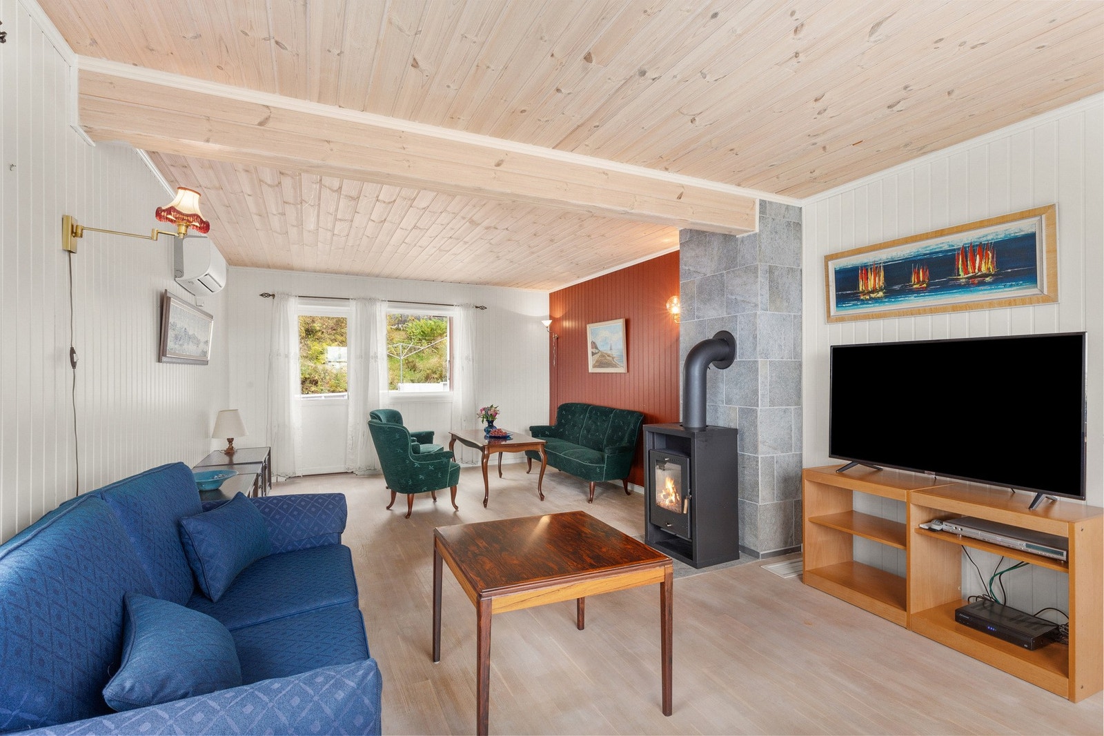 I 1.etasjen finner du en innbydende stue som varmes med vedfyring og varmepumpe Galleribilde