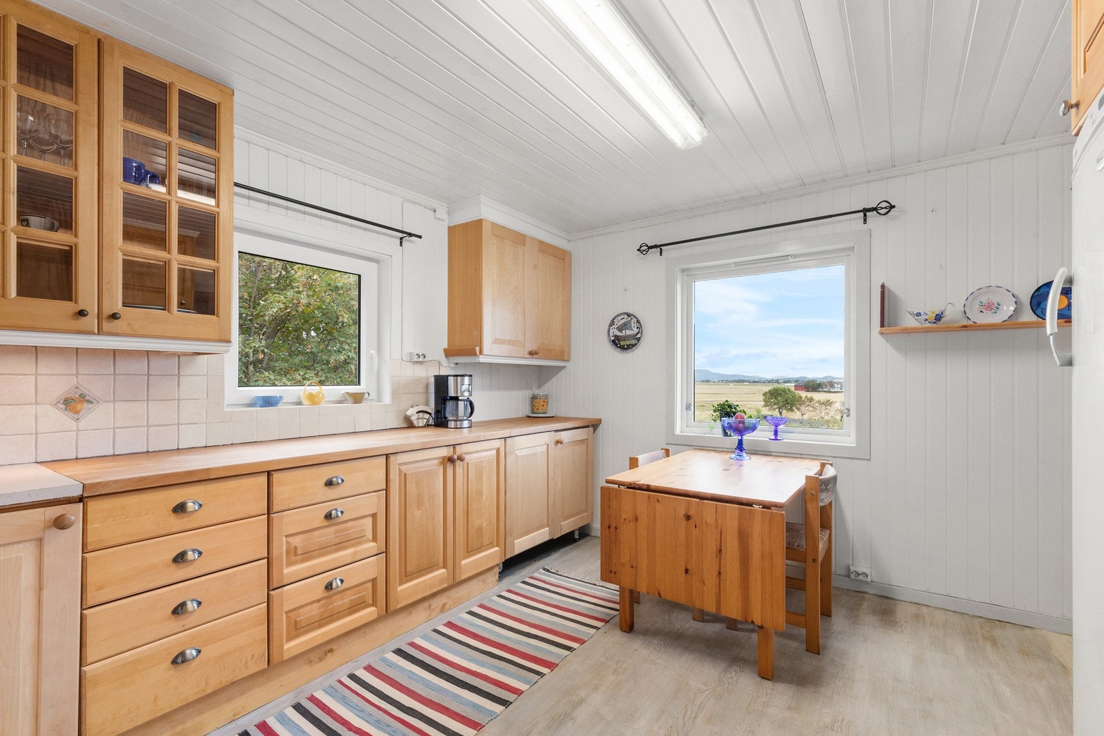 Solid kjøkken med masse skapplass og rom for frokostbord Galleribilde