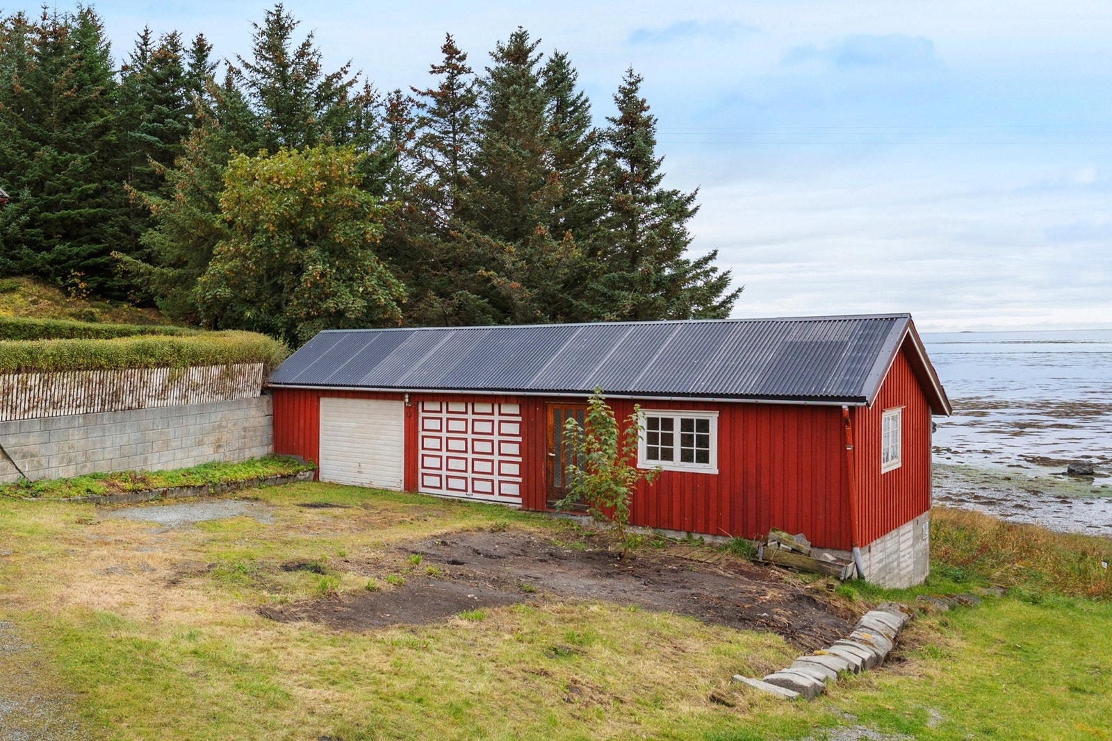 Dobbeltgarasje på 60 kvm med en elektrisk port, stort hobbyrom og grovkjeller. Galleribilde
