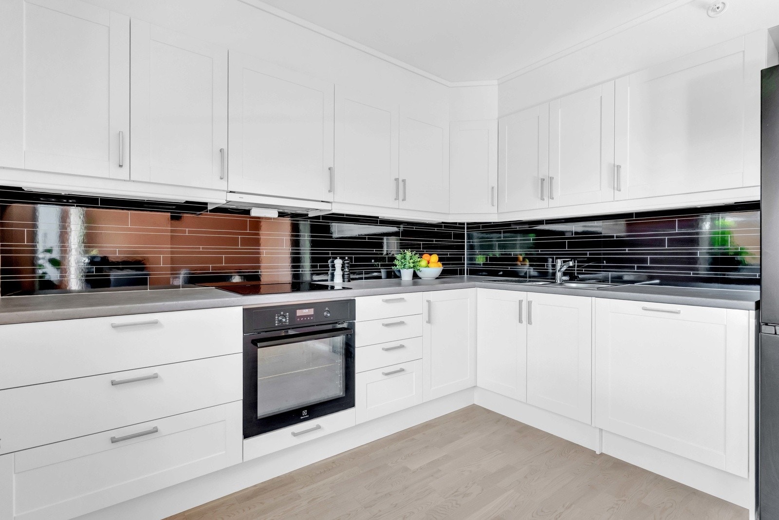 Kjøkkenet er tidløst og praktisk, oppført i en funksjonell L-form med god arbeidsflyt og skapplass Galleribilde