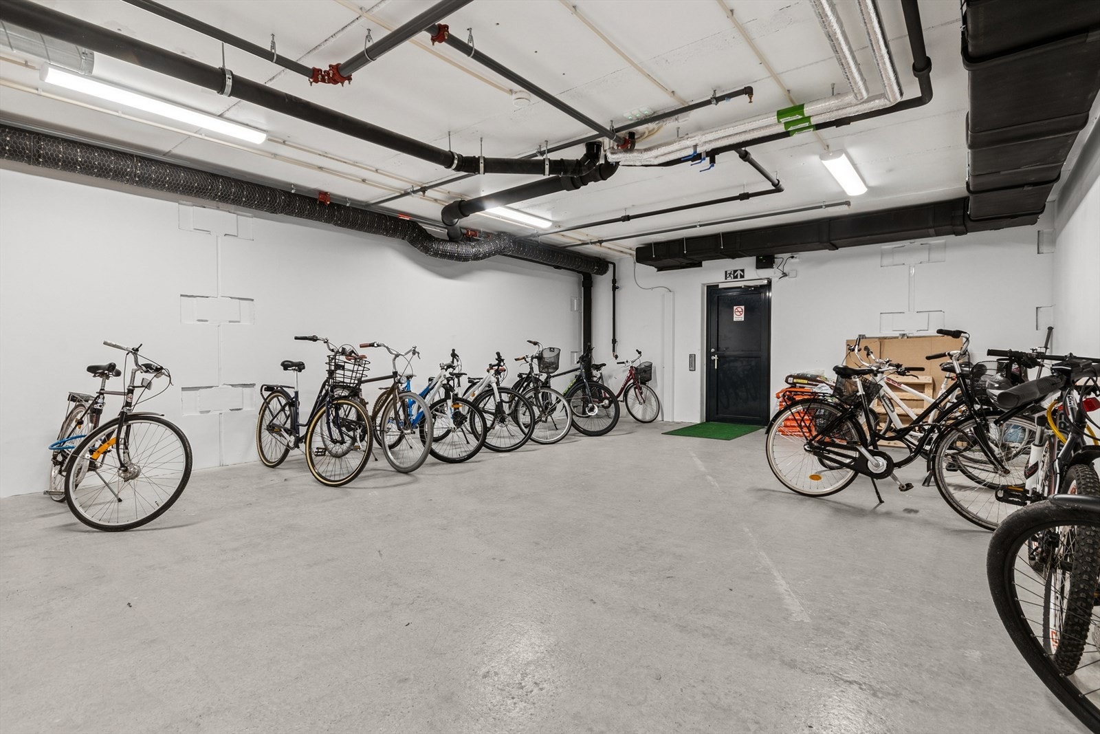 Underetasjer med garasjeplasser, sykkelparkeringer og boder. Galleribilde