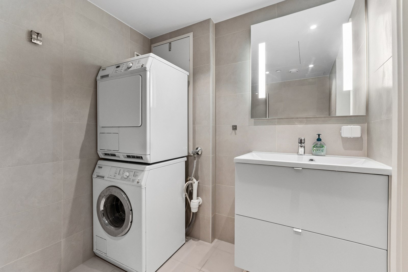 Leiligheten er innredet med flislagt bad og flislagt toalettrom. Badeværelset er komplett med toalett, dusjhjørne, servant og opplegg til vaskemaskin. Galleribilde