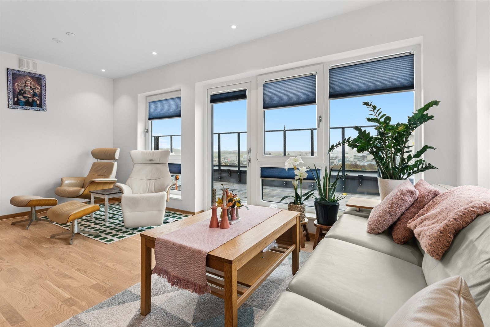 Store vinduer som strekker seg ned mot gulv og glassrekkverk som slipper lyset inn. Galleribilde