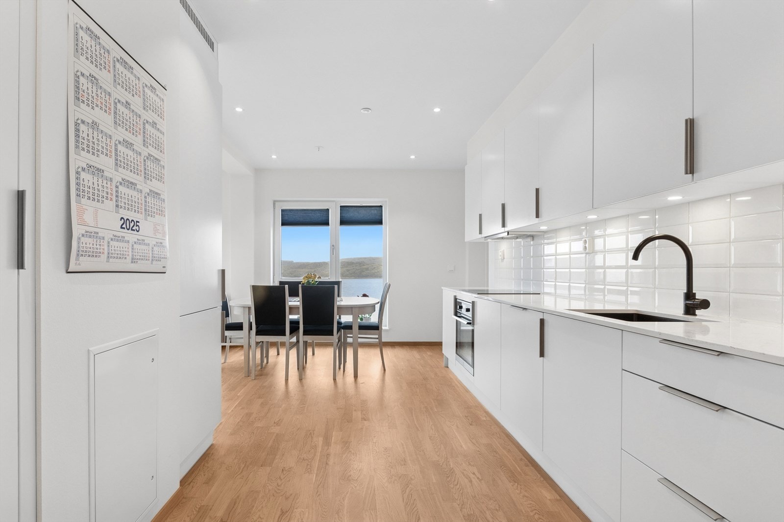 Lekre fliser som speiler seg i daglys og belysning fra overskapene. Galleribilde